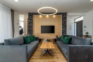 a living room with a couch and a tv at Villa Eden with heated pool in Omiš