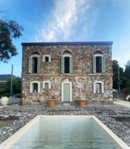 a stone house with a pool in front of it at Casello 79 Rais in Finale
