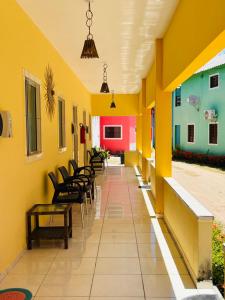 Eine Stuhlreihe in einem Flur mit gelben Wänden in der Unterkunft Fonte dos Corais - Suíte Lua na Praia in Maragogi + 27 Fotos