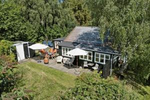 Una vista aérea de una casa con un patio con sombrillas. en Træhus Med Vild Have Ved Sejerøbugten, en Kalundborg