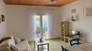 a living room with a couch and a tv at Ždrelac Guest House in Ždrelac