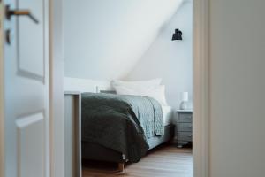 - une chambre blanche avec un lit et une table de nuit dans l'établissement Spreewaldhaus Am Landgut Das Haupthaus, à Markische Heide