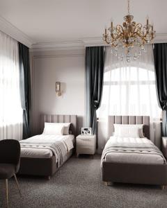 une chambre avec deux lits et un lustre dans l'établissement Prima Villa Boutique Hotel отель, à Semey