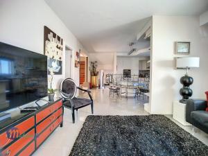 un salon avec une télévision et un canapé dans l'établissement Pearls Beach Villa, à Porto Moniz