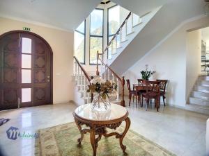 un salon avec une table avec un vase de fleurs dessus dans l'établissement Pearls Beach Villa, à Porto Moniz