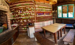 a room with a table and benches and a wall of wine bottles at Todo se transforma in Cuchilla Alta