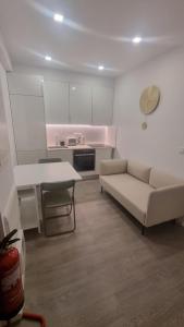 een witte woonkamer met een bank en een tafel bij Braga 2 Bedrooms Nice Flat in Braga