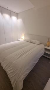 een groot wit bed in een witte kamer bij Braga 2 Bedrooms Nice Flat in Braga