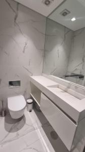 een witte badkamer met een toilet en een spiegel bij Braga 2 Bedrooms Nice Flat in Braga