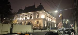 ein beleuchtetes Gebäude auf einer Stadtstraße bei Nacht in der Unterkunft Cozy central studio in Craiova
