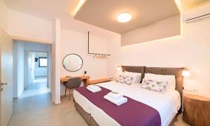 une chambre avec un grand lit et un bureau dans l'établissement Orientem Villa Beheizter Pool, à Georgioúpoli 27 autres photos