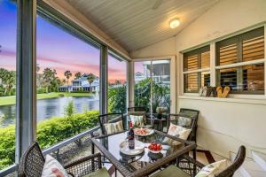 een veranda met een tafel en stoelen en uitzicht op het water bij Siesta Bayside Condo in Siesta Key