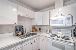 una cocina con armarios blancos y un horno de fogón blanco en Vegas Adventure Starts Here-Mins to Strip! Sleep 6!, en Las Vegas