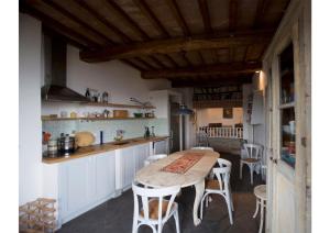 une cuisine avec une table et des chaises dans une pièce dans l'établissement Hochwertige Wohnung Im Turm Schlösschen, à Montemerano