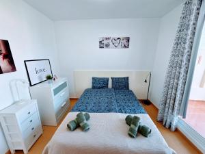 a bedroom with a bed with two teddy bears on it at Canary Dreams Ocean View in Playa del Cura +34 photos