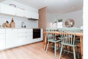 une cuisine avec une table et des chaises en bois dans l'établissement Spreewaldhaus Am Landgut Der Stall, à Markische Heide