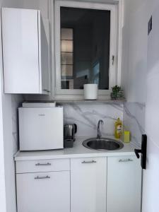 Una encimera de cocina con fregadero y microondas. en Royal Blue Central Point, en Sarajevo 58 fotos más