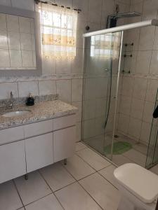 une salle de bain avec douche, lavabo et toilettes dans l'établissement Andradas House - Casa em Uruguaiana, à Uruguaiana
