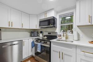 a kitchen with white cabinets and a stove top oven at Little Indale Haus - Near Downtown and Prince Ave in Athens