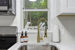 a kitchen sink with wine bottles and a window at Little Indale Haus - Near Downtown and Prince Ave in Athens +20 photos