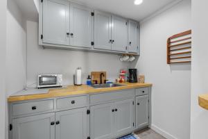 a kitchen with white cabinets and a sink at The Briarcliff Suite in Athens