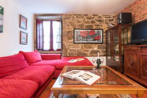 ein Wohnzimmer mit einem roten Sofa und einem Tisch in der Unterkunft Casa Dos Pazos in Brion