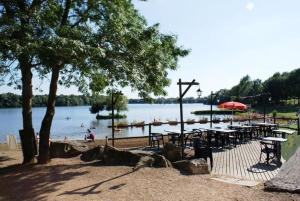 ein Strand mit Tischen und Stühlen und Menschen im Wasser in der Unterkunft Gite Du Randonneur in Sennecey-le-Grand
