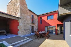 un patio avec une table et des chaises à côté d'un bâtiment dans l'établissement Villa Mit Viel Platz Und Pool In Vila Cova, à Gemezes