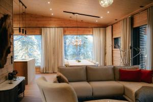 ein Wohnzimmer mit Couch und großem Fenster in der Unterkunft Aurora B Luxury Lodge in Kuusamo