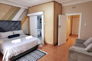 ein Schlafzimmer mit einem großen Bett und einer Couch in der Unterkunft Neema Lodge in Boksburg