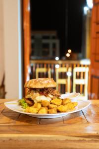 a sandwich and tater tots on a plate on a table at Hotel Colonial Abejorral in Abejorral +92 photos
