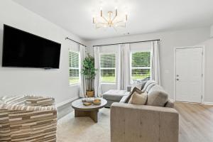 ein Wohnzimmer mit Sofa und Fernseher in der Unterkunft New Listing The Neutral Nook with Firepit in Athens