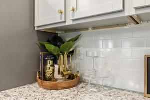 eine Küchentheke mit einem Korb voller Weinflaschen und Gläsern in der Unterkunft New Listing The Neutral Nook with Firepit in Athens + 33 Fotos