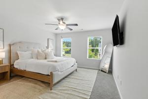 ein weißes Schlafzimmer mit einem Bett und einem Deckenventilator in der Unterkunft New Listing The Neutral Nook with Firepit in Athens