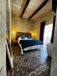 a bedroom with a bed and a tub in a room at Phi Home Bormla in Birgu