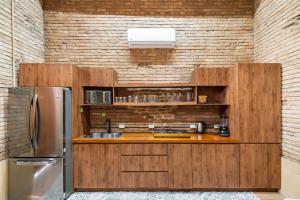 een keuken met houten kasten en een roestvrijstalen koelkast bij Hacienda Tapia in Monterrey +9 foto's