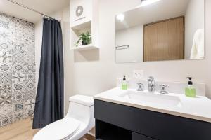 een badkamer met een wastafel, een toilet en een spiegel bij Hacienda Tapia in Monterrey