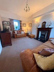 un salon avec un canapé et une cheminée dans l'établissement Private Holiday Home with 4 bedrooms- Tower street Guest House, à Selkirk