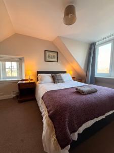 une chambre avec un grand lit et deux fenêtres dans l'établissement Private Holiday Home with 4 bedrooms- Tower street Guest House, à Selkirk