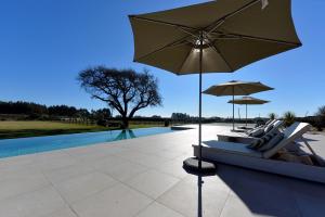 eine Terrasse mit einem Sofa, einem Sonnenschirm und einem Pool in der Unterkunft Ferienhaus für 12 Personen in Esposende, Regio Norte Parque Natural do Litoral Norte in Esposende + 32 Fotos