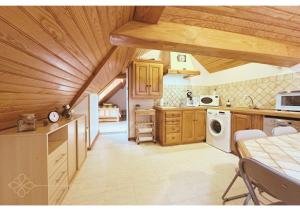 a kitchen with wooden cabinets and a white appliance at Bel appartement 4 à 6 personnes, ambiance chalet in Eaux-Bonnes
