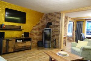 a living room with a fireplace and a tv on a brick wall at Haus Molle in Benneckenstein
