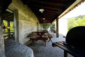 eine Terrasse mit einem Tisch und Bänken auf einer Steinmauer in der Unterkunft Ferienhaus für 10 Personen in Cossourado, Regio Norte Minho in Linhares