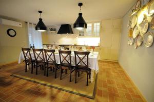 eine Küche mit einem Tisch mit Stühlen und eine Küche mit einer Theke in der Unterkunft Ferienhaus für 10 Personen in Cossourado, Regio Norte Minho in Linhares