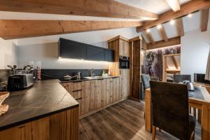 Una cocina con gabinetes de madera y encimera. en Suite Illuminata con piccolo centro wellness, en Commezzadura