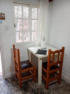 un tavolo bianco con due sedie accanto a una finestra di Cabañas Pueblo de J e s u s a Potrero de los Funes