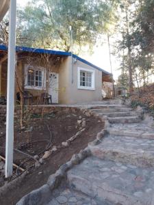 une maison avec une passerelle en pierre devant elle dans l'établissement Cabañas Pueblo de J e s u s, à Potrero de los Funes