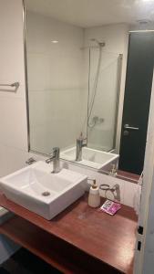 een badkamer met een wastafel, een spiegel en een bad bij El rejunte , CABA in Buenos Aires +7 foto's