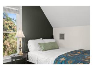 a bedroom with a bed and a window and a lamp at New listing! The Terra Cotta Bungalow with Firepit in Athens
