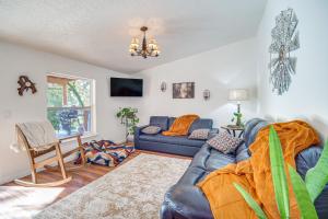 een woonkamer met een blauwe bank en een tv bij Riverfront Relaxation Secluded Jacksonville Home in Buncom